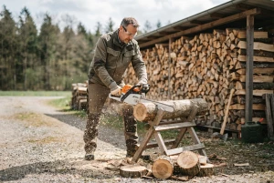 Brennholz wird mit einer Kettensäge zugeschnitten