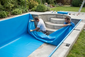 Blaue Poolfolie wird in einem Gartenpool verlegt