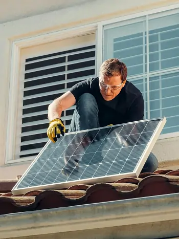 Garten mit Solarstrom versorgen, ein Arbeiter montiert Solarpanele
